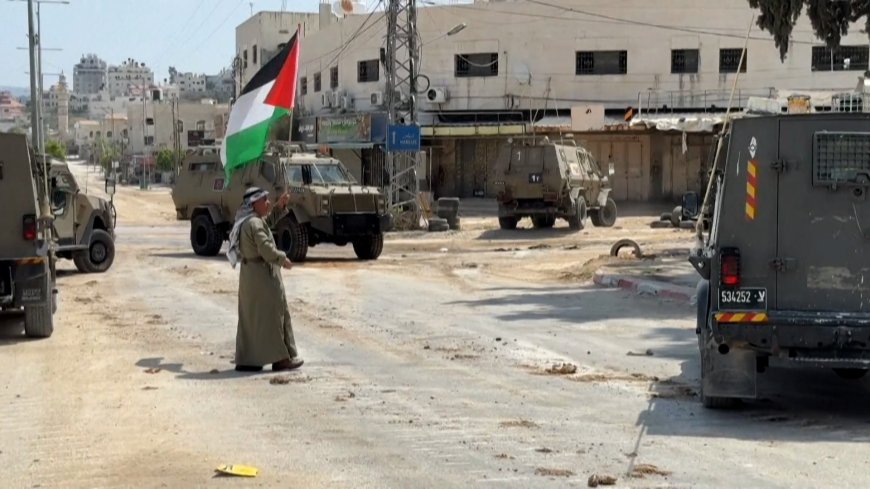 Video: Palestinian waves flag in front of Israeli military vehicles